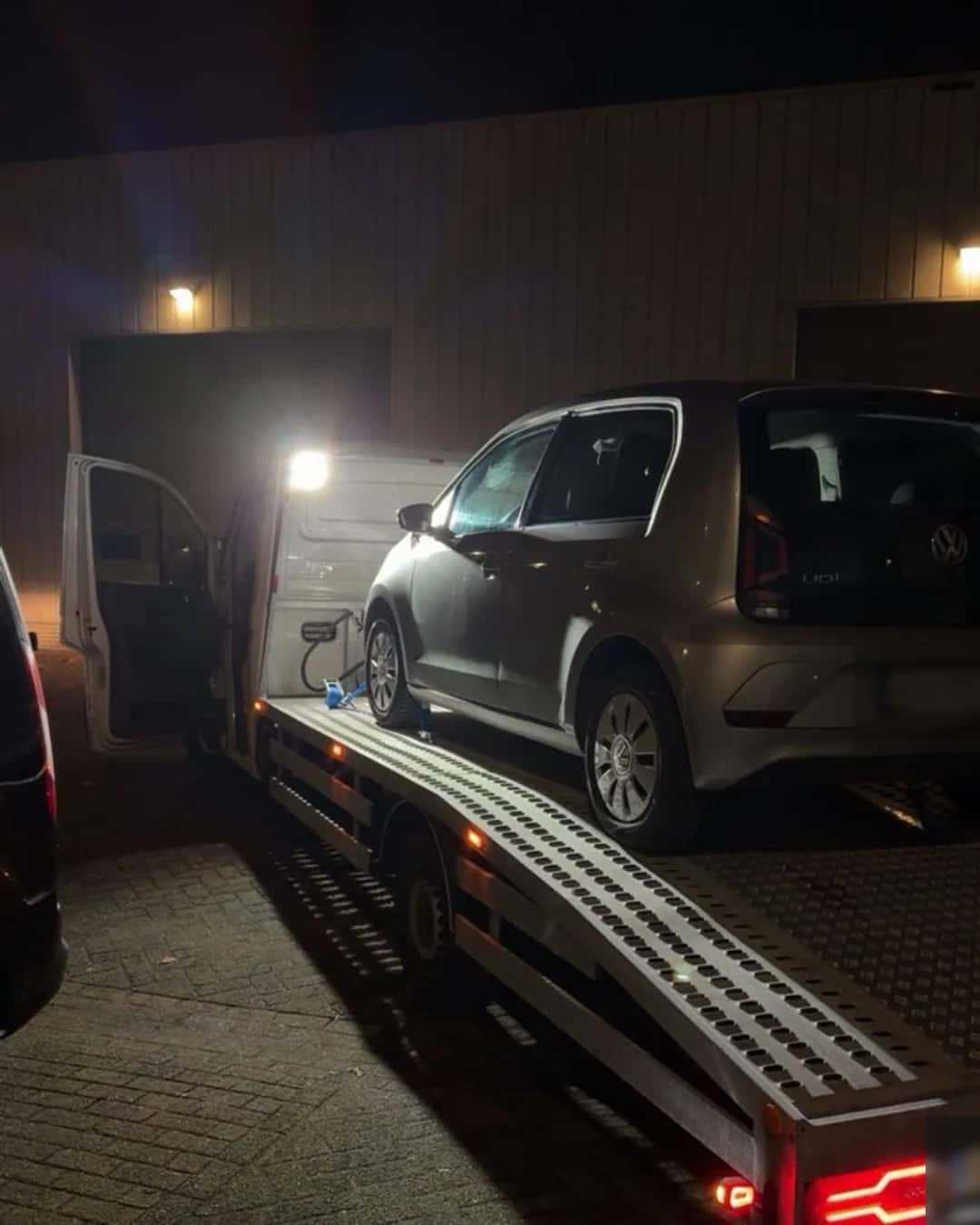 Personenauto op de oprijwagen tijdens een transportopdracht in de avond