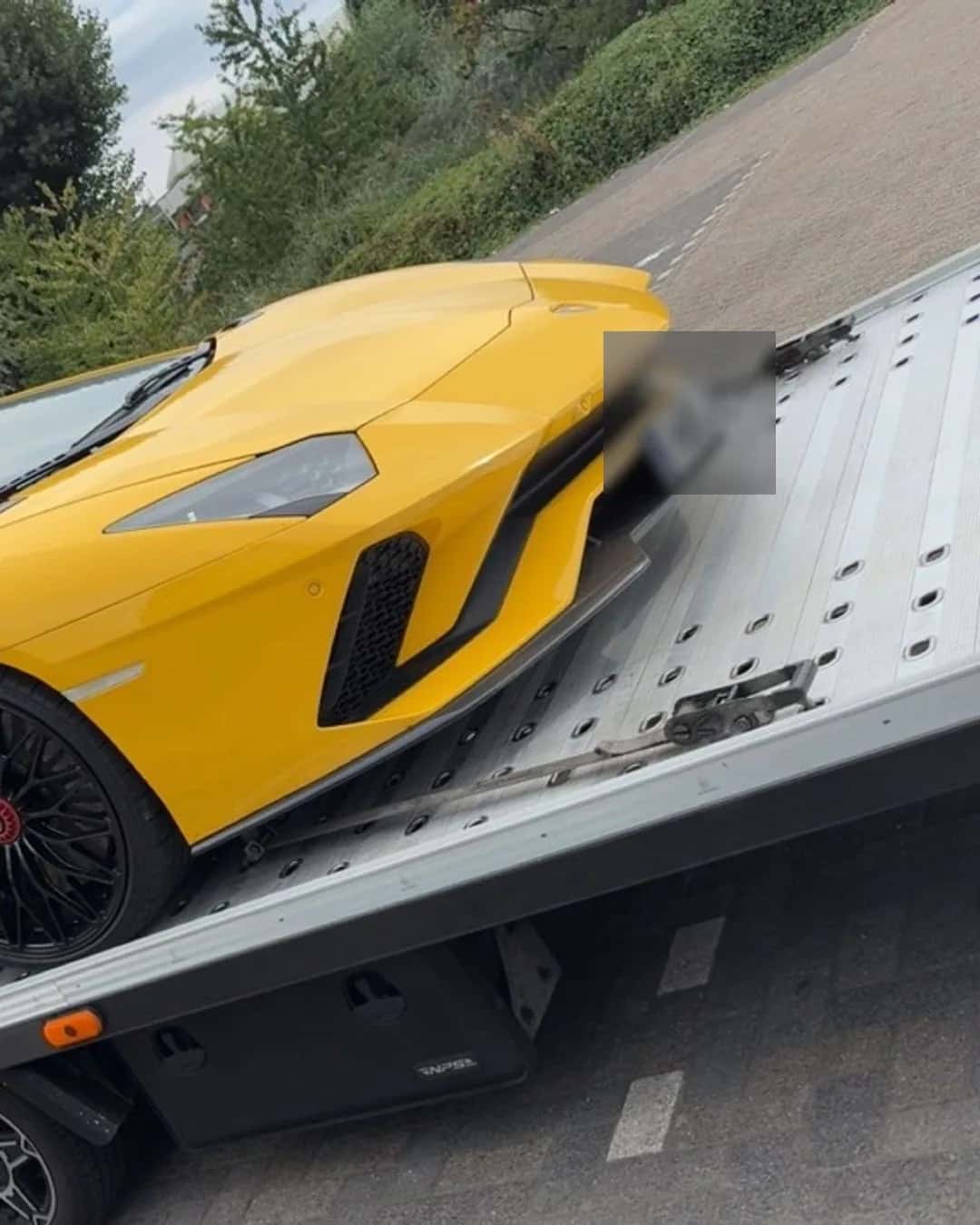 Gele sportwagen op een autotransporter